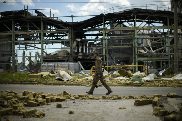 Ukrajinský voják u zničené továrny ve městě Bachmut na snímku z 28. května. Foto: ČTK/AP