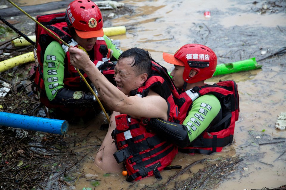 Záchranáři pomáhají muži, který uvízl v rozvodněných vodách: vesnice Še v jihočínské provincii Fu-ťien, 18. června 2022. Foto: China Daily via Reuters