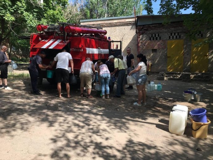 Lidé si nabírají vodu z cisterny v Mariupolu okupovaném ruskými vojsky a ohroženém cholerou a dalšími chorobami ze znečištěné vody, 9. června 2022. Foto: Latin America News Agency via Reuters