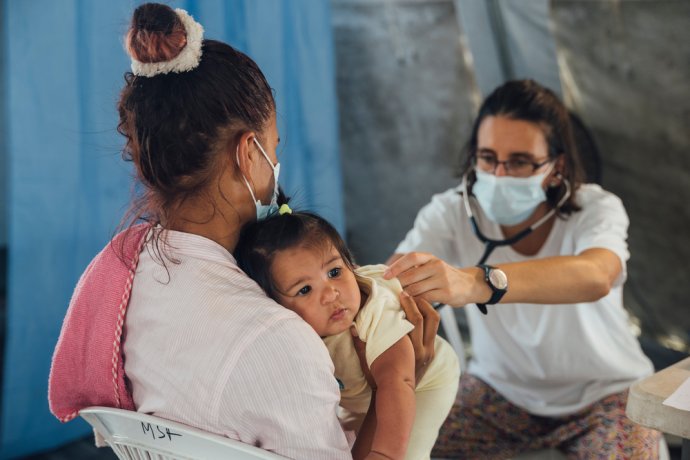 Venezuelanka se svou jednoroční dcerou překonala Dariénskou proluku. V přijímacím středisku v Panamě prohlíží dítě lékař. Foto: Oliver Barth, Lékaři bez hranic