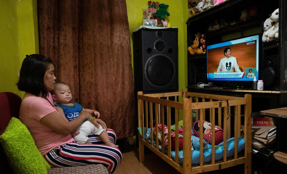 Jaká budoucnost čeká jejího syna? Je 25. července 2022 a Filipínka v Manile sleduje v přímém televizním přenosu, jak se nový prezident Ferdinand Marcos Jr. ujímá funkce. Marcos za prioritu své vlády prohlásil potravinovou bezpečnost - a měl k tomu pádné důvody. Foto: Lisa Marie David, Reuters