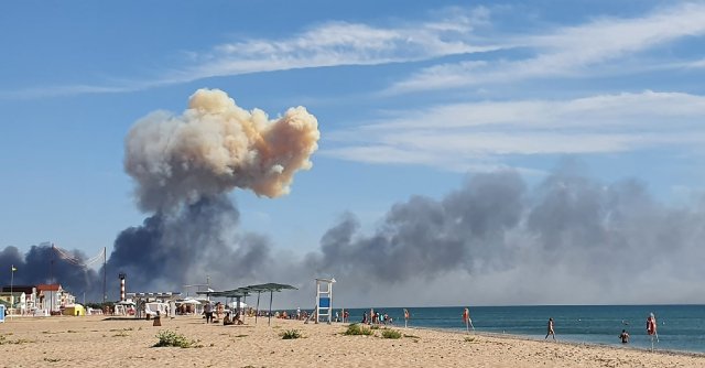 Stoupající kouř na obzoru dosud idylické pláže na Krymu po zásahu letecké základny Saky 9. srpna. Foto: ČTK/AP