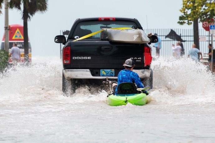 Záplavy po hurikánu Ian způsobily v ulicích měst na západním pobřeží Floridy takové záplavy, že mnohé silnice byly odříznuty od automobilové dopravy. Muž na snímku se rozhodl plavit ulicemi na kajaku. Foto: Mary Martin, ČTK/AP