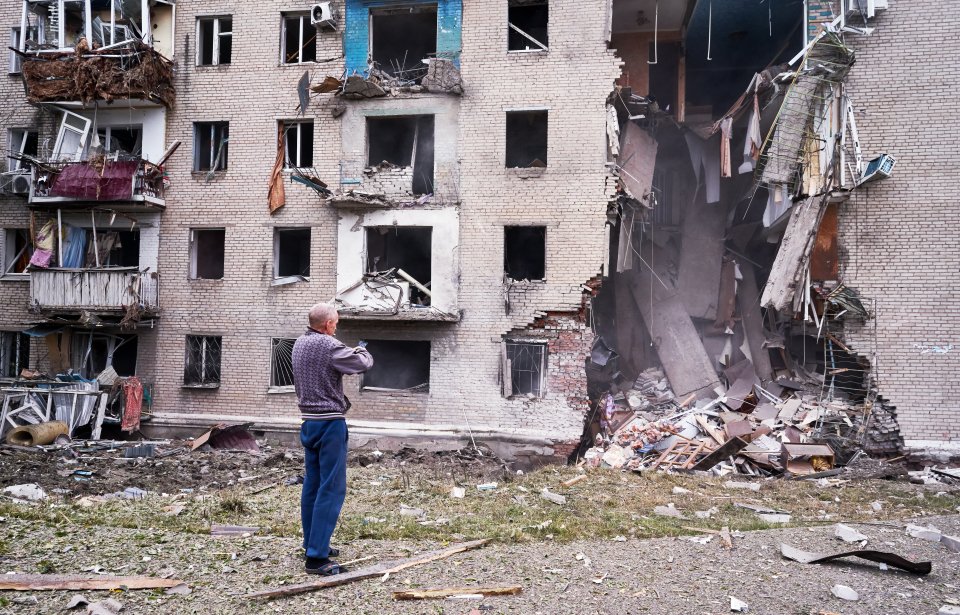 "Muž si fotí na mobil zničený činžák. Dopadly na něj dvě ruské rakety. Září 2022. Foto: Iva Zímová