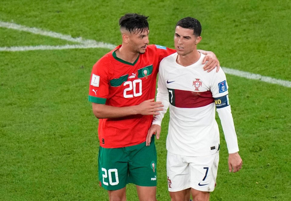 Marocký hráč Ašraf Darí mluví k Portugalci Cristianu Ronaldovi po konci utkání. I další afričtí hráči poté zklamaného Ronalda utěšovali. Foto: Luca Bruno, ČTK / AP