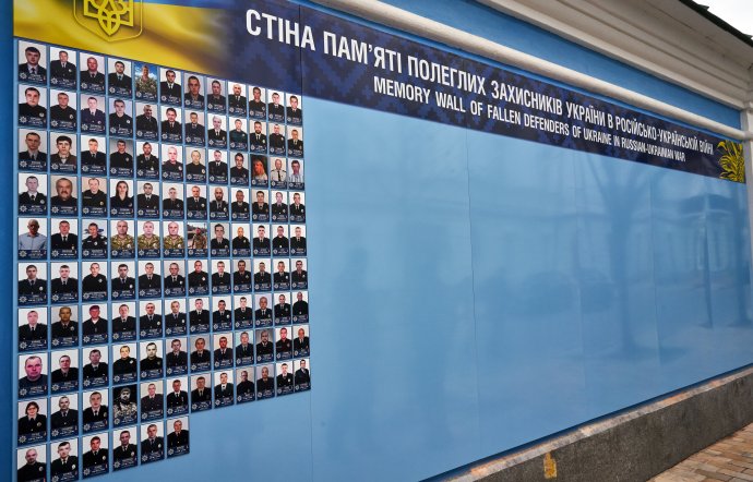 Stěna, na kterou jsou připevňovány v Kyjevě fotografie padlých, musela být rozšířena. Ukrajina tuší, že v roce 2023 se zaplní dalšími portréty. Foto: Iva Zímová, Panos Pictures