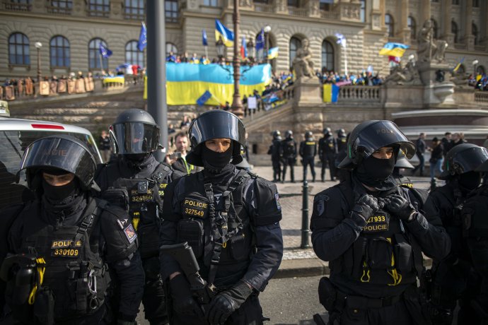 Policisté na protivládní demonstraci v Praze oddělují demonstranty od jejich odpůrců s ukrajinskými vlajkami. Nenávist vůči Ukrajině, Ukrajincům a jejich symbolům je na protivládní scéně všudypřítomná. Její lídři ji eskalují, současně si ale vytvářejí alibi, aby mohli říct, že za nic nemohou. Foto: Gabriel Kuchta, Deník N