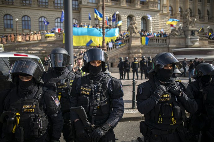 Policisté na protivládní demonstraci v Praze oddělují demonstranty od jejich odpůrců s ukrajinskými vlajkami. Nenávist vůči Ukrajině, Ukrajincům a jejich symbolům je na protivládní scéně všudypřítomná. Její lídři ji eskalují, současně si ale vytvářejí alibi, aby mohli říct, že za nic nemohou. Foto: Gabriel Kuchta, Deník N