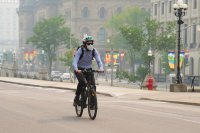 Cyklista v kanadské Ottawě má na sobě roušku kvůli kouři z lesů, který znečistil vzduch jak v Kanadě, tak i v sousedních Spojených státech. Kouřová mlha zasáhla i New York a Jižní Karolínu. Foto: Sean Kilpatrick, AP/ČTK
