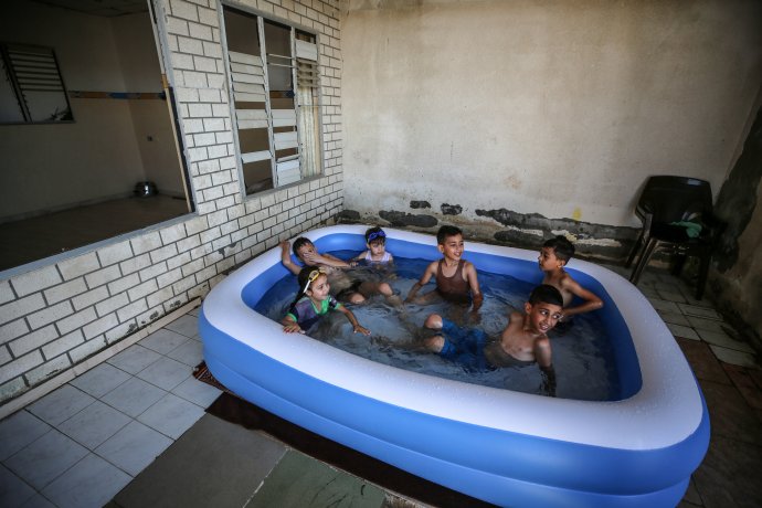 Vlna veder se nevyhýbá ani Blízkému východu. Na snímku se ochlazují palestinské děti v bazéně na střeše budovy v Gaze, 17. července 2023. Foto: Majdi Fathi, NurPhoto via Reuters
