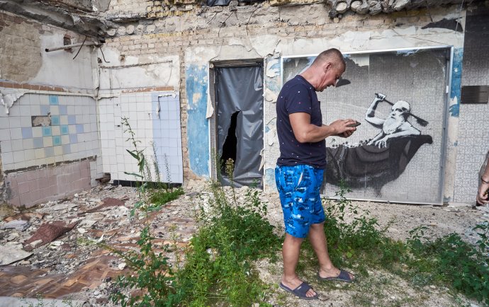 Řidič Saša ve své chodbě. "Toho Banksyho mi byl čert dlužen," hudruje a neustále píše úřadům, že chce zpátky své ruiny. Bez muže ve vaně. Foto: Iva Zímová