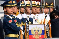 V pozoru! Příslušníci čínské čestné stráže a ruská vlajka se státním znakem coby kulisy příletu Vladimira Putina do Pekingu (17. října 2023). Foto: Parker Song, Reuters