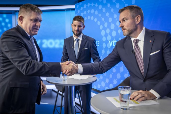 Michal Šimečka se dívá, jak si podávají ruce Robert Fico a Peter Pellegrini v debatě TA3. Foto: Tomáš Benedikovič, Denník N