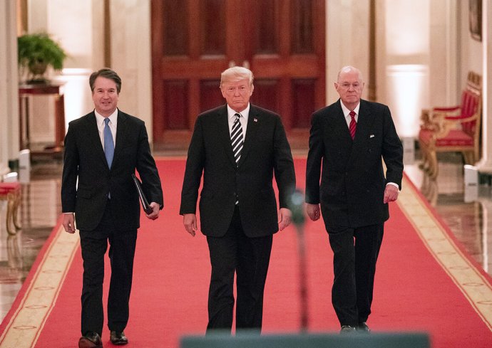 Donald Trump na snímku z 8. října 2018 v Bílém domě obklopen odcházejícím soudcem Nejvyššího soudu Anthonym Kennedym (vpravo) a nastupujícím, Trumpem nominovaným Brettem Kavanaughem. Právě ten bude nyní jedním z těch, kdo rozhodne, zda se ústavní dodatek brání Trumpovi znovu se ucházet o prezidentský post. Foto: Joyce N. Boghosian, Flickr