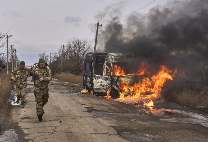 Ukrajinští vojáci nedaleko Bachmutu projíždějí kolem autobusu zničeného po zásahu ruským dronem. Foto: Shandyba Mykyta / AP / ČTK