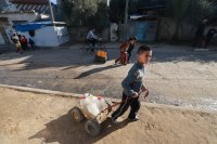 Vysídlené palestinské děti nosí vodu zpět do stanu. V reakci na některé z nejnaléhavějších potřeb vysídlených lidí v Rafáhu zahájily týmy Lékařů bez hranic v prosinci 2023 program distribuce vody. V současnosti poskytují v průměru 110 000 litrů nezávadné pitné vody denně asi 20 000 lidí. Foto: Lékaři bez hranic