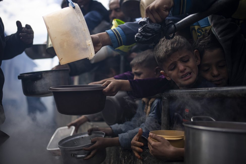 Snímek z minulého roku zachycuje Palestince čekající v Rafáhu ve frontě na jídlo. Město je dnes součástí nárazníkové zóny Izraele. Foto: ČTK/AP
