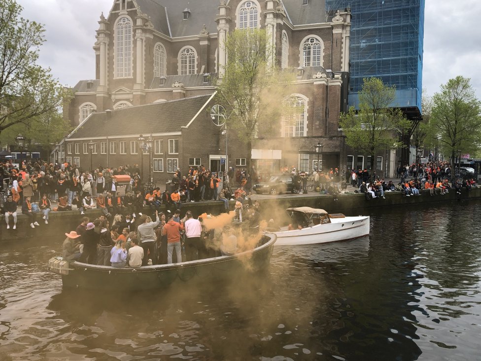 Oranžové dýmovnice v sobotu odpoledne v centru Amsterdamu. Foto: Tomáš Linhart, Deník N