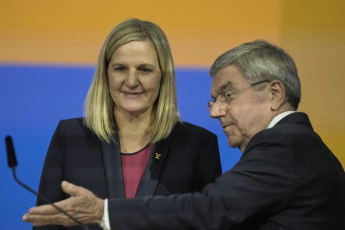 Dosluhující předseda Mezinárodního olympijského výboru Thomas Bach přivádí k mikrofonu svou nástupkyni Kirsty Coventry. Foto: Thanassis Stavrakis, AP/ČTK