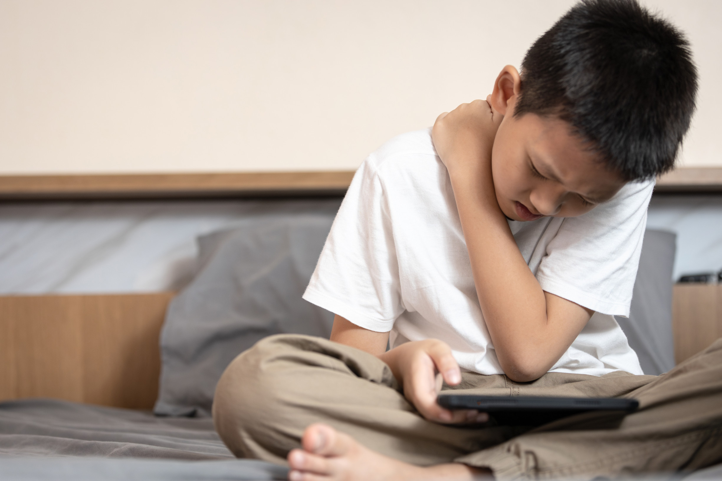 Děti se skloněnou hlavou. Bolesti krční páteře řeší třeba už ve dvanácti